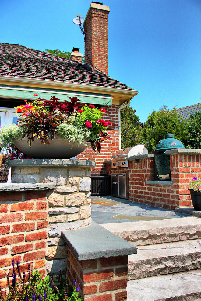 На фото: участок и сад на заднем дворе в классическом стиле с покрытием из каменной брусчатки и подпорной стенкой с