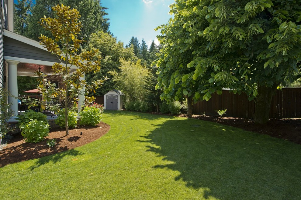 Inspiration for a mid-sized traditional partial sun backyard landscaping in Seattle with a fire pit and decking for summer.