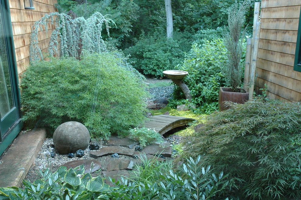 Aménagement d'un petit jardin sur cour asiatique l'été avec une exposition ombragée et du gravier.