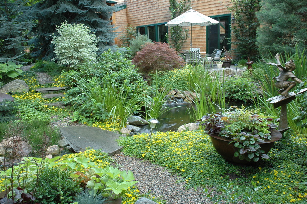 Imagen de jardín tradicional grande en verano en patio trasero con estanque y exposición parcial al sol