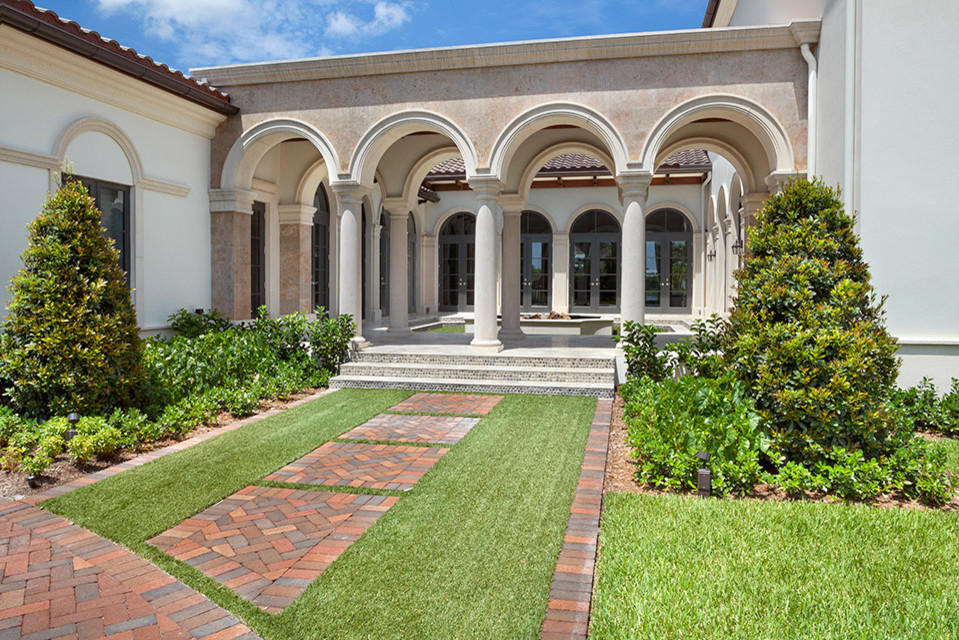 Immagine di un grande giardino formale mediterraneo esposto in pieno sole in cortile con pavimentazioni in mattoni