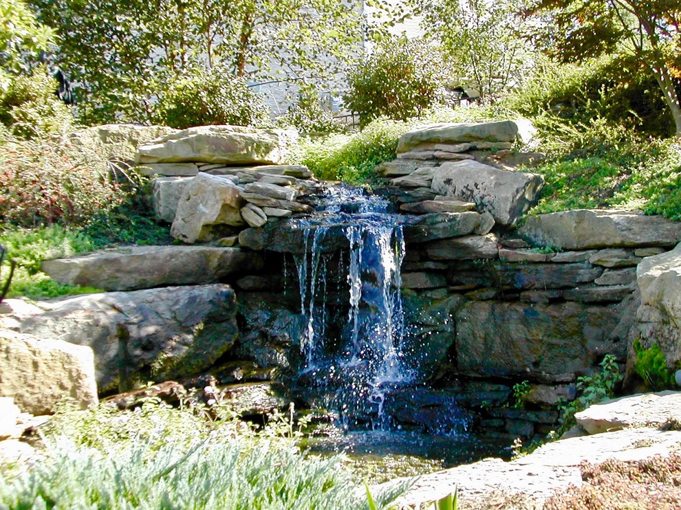 Стильный дизайн: солнечный, летний садовый фонтан среднего размера на склоне в стиле рустика с хорошей освещенностью и покрытием из каменной брусчатки - последний тренд