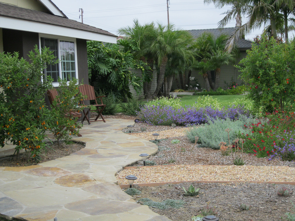 На фото: солнечный участок и сад среднего размера на переднем дворе в средиземноморском стиле с хорошей освещенностью и покрытием из гравия