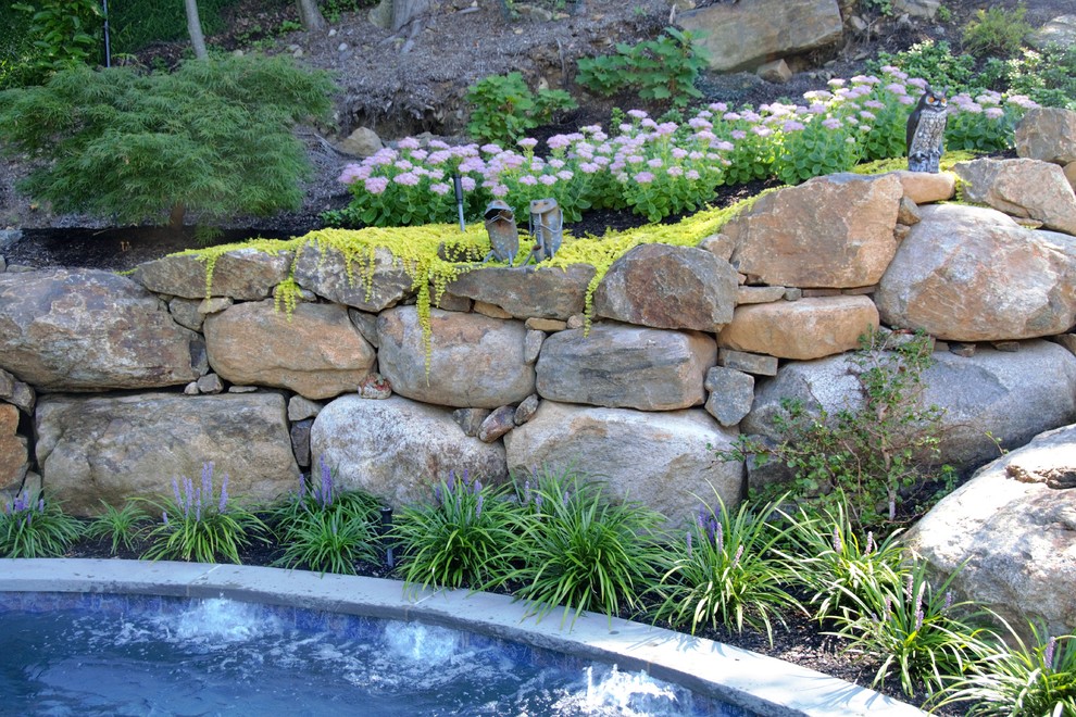 Ejemplo de jardín rural pequeño en patio trasero con fuente, exposición total al sol y adoquines de piedra natural
