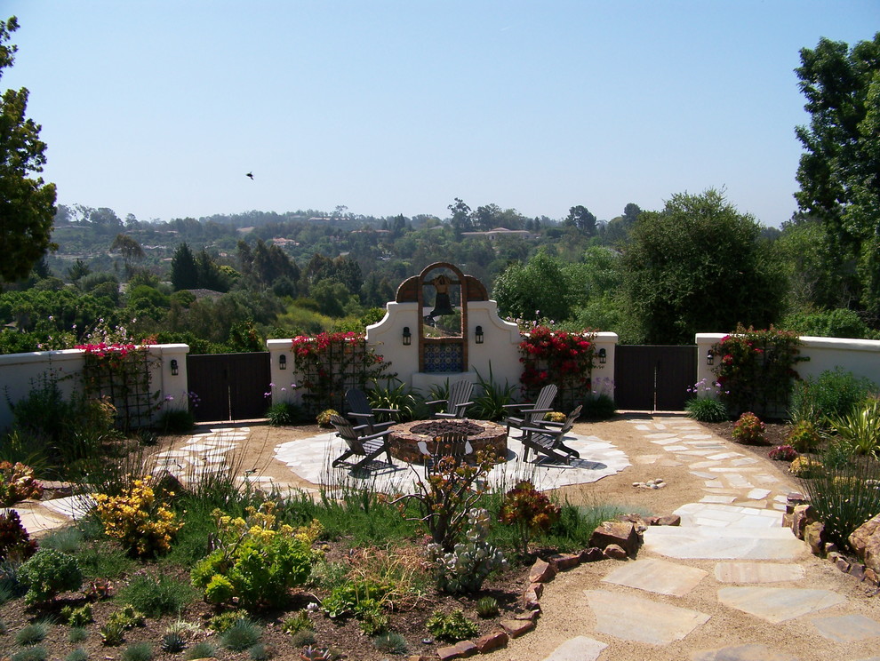 Large back xeriscape full sun garden for summer in San Diego with a fire feature and natural stone paving.