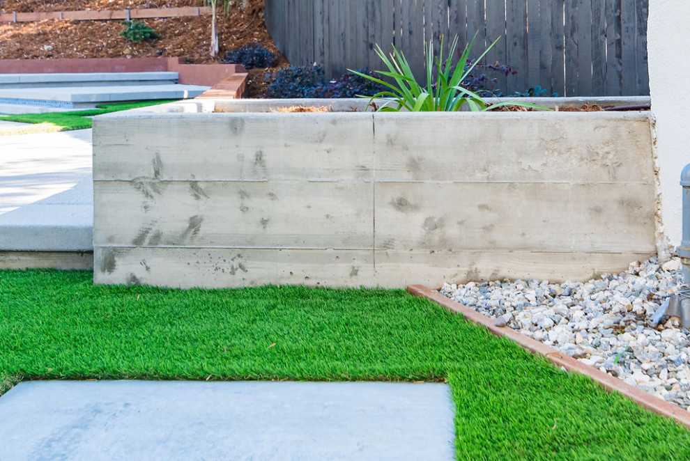 Photo of a large contemporary partial sun backyard concrete paver landscaping in Los Angeles for summer.