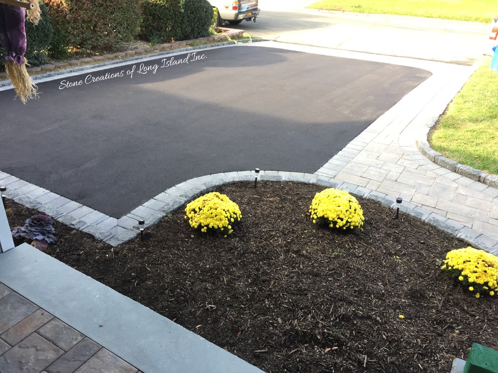 Photo of a large traditional front yard concrete paver driveway in New York.