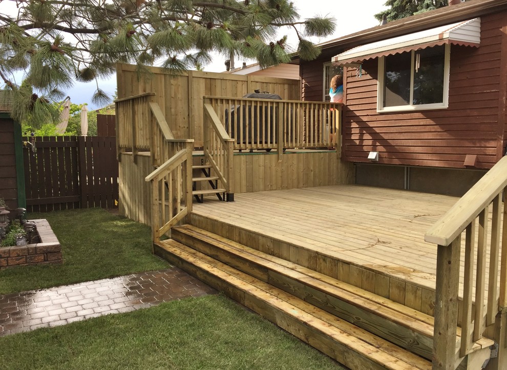 Design ideas for a large contemporary partial sun backyard landscaping in Edmonton with decking.