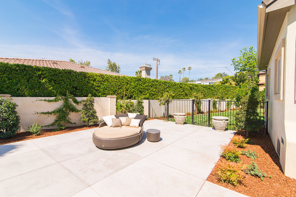 Großer, Halbschattiger Moderner Garten im Sommer, hinter dem Haus mit Betonboden in Los Angeles