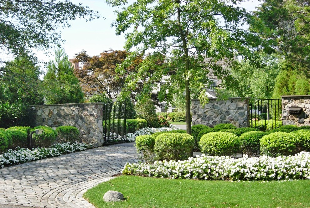 Foto di un grande vialetto d'ingresso american style esposto in pieno sole davanti casa in primavera con un ingresso o sentiero e pavimentazioni in cemento
