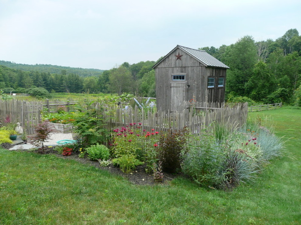 Immagine di un piccolo giardino country esposto in pieno sole dietro casa con un giardino in vaso e ghiaia