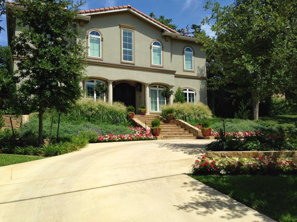 Photo of a large mediterranean full sun front yard stone driveway in Dallas.