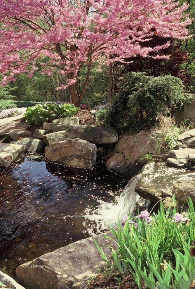 Inspiration för stora klassiska trädgårdar i delvis sol, med en fontän och naturstensplattor