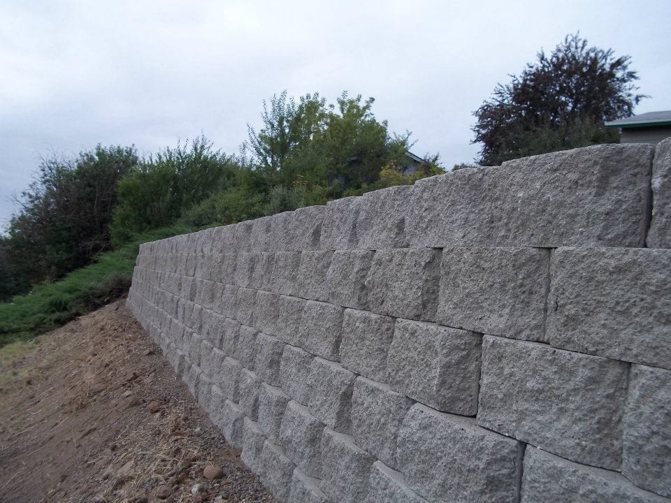 Photo of a mid-sized traditional partial sun backyard concrete paver retaining wall landscape in Seattle.