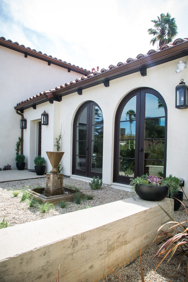 This is an example of a transitional drought-tolerant and full sun front yard gravel landscaping in Los Angeles.