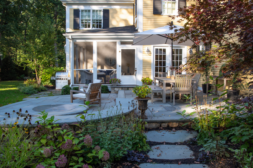 Photo of a medium sized traditional back partial sun garden in Boston with a fire feature and natural stone paving.
