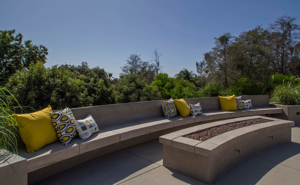 Idee per un grande giardino design esposto in pieno sole dietro casa in estate con un focolare e pavimentazioni in cemento