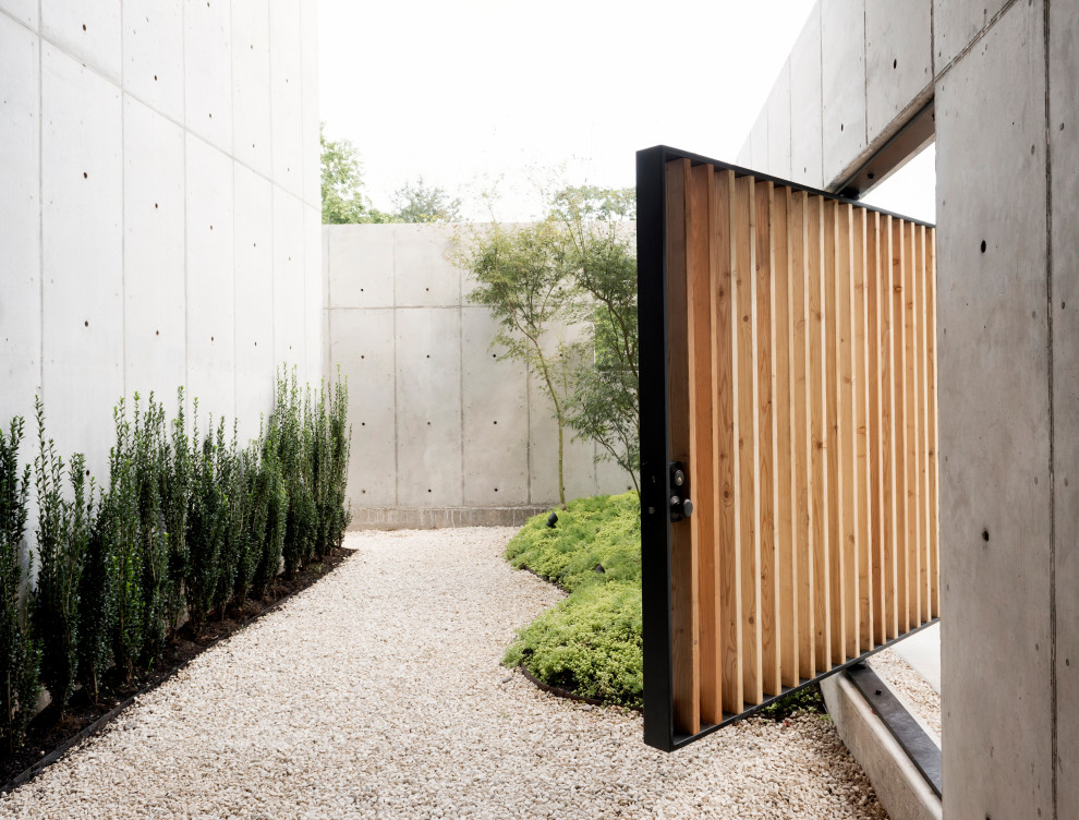 Idee per un giardino xeriscape minimalista davanti casa con un ingresso o sentiero e ghiaia