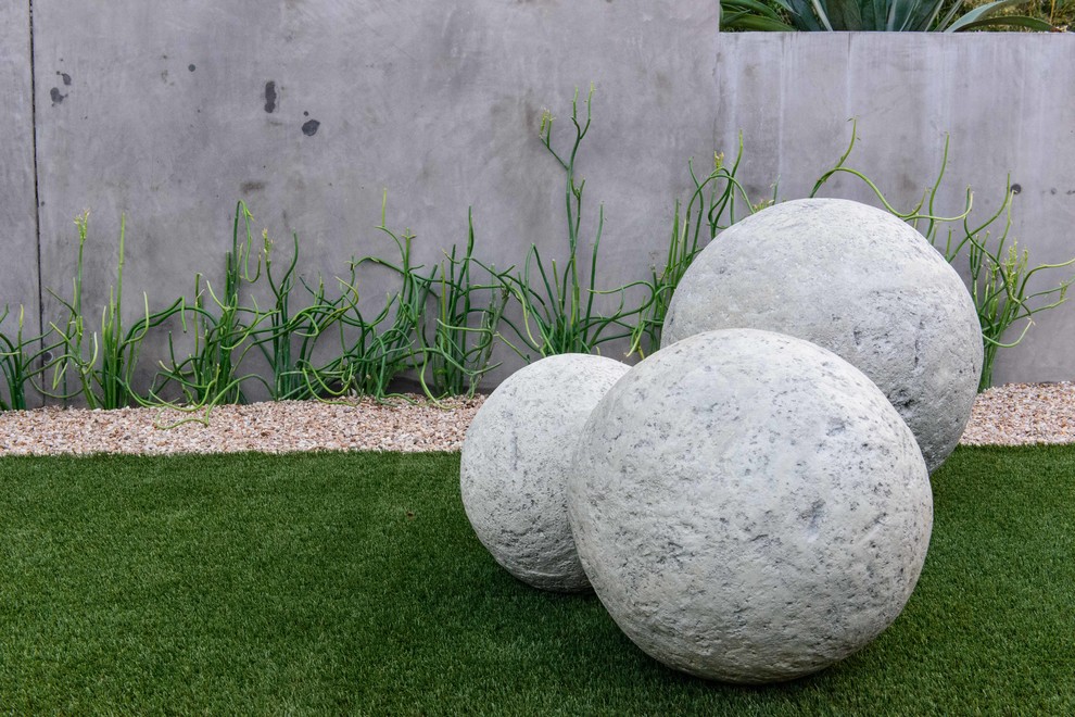 Cette image montre un jardin à la française avant minimaliste de taille moyenne et au printemps avec du gravier, une exposition ensoleillée et des solutions pour vis-à-vis.