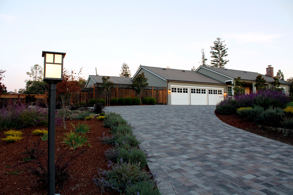 На фото: большой участок и сад на переднем дворе в современном стиле с мощением тротуарной плиткой и подъездной дорогой