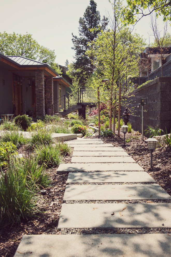 Свежая идея для дизайна: солнечный регулярный сад среднего размера на переднем дворе в стиле модернизм с подпорной стенкой, хорошей освещенностью и мощением тротуарной плиткой - отличное фото интерьера
