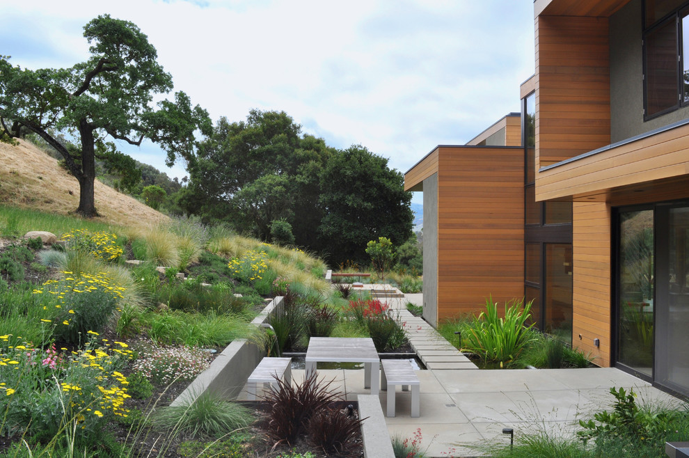 Пример оригинального дизайна: участок и сад в стиле модернизм с подпорной стенкой