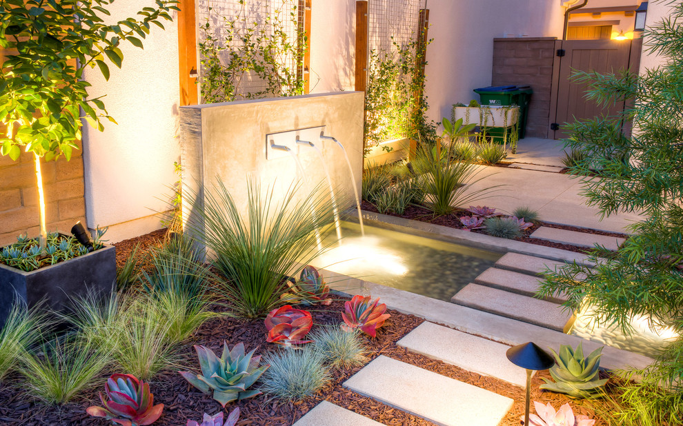 Imagen de jardín moderno pequeño en patio lateral con fuente, exposición total al sol y adoquines de hormigón