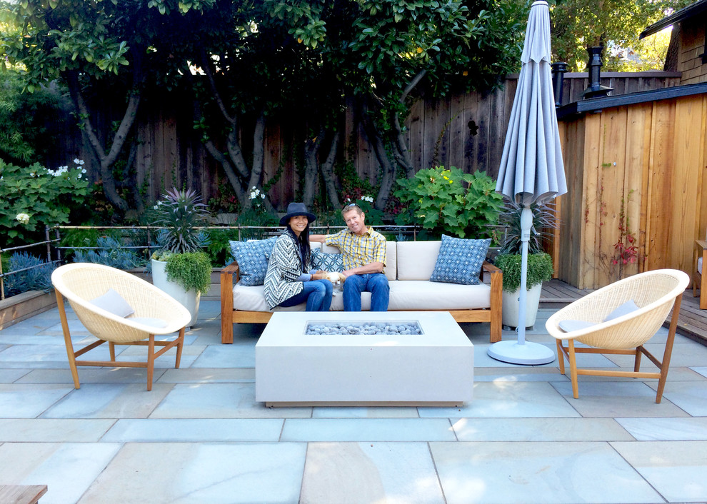 Foto di un patio o portico minimalista dietro casa con un focolare e pavimentazioni in pietra naturale