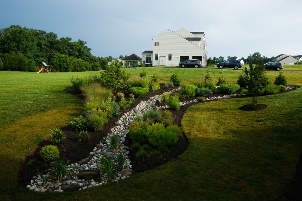Idee per un grande laghetto da giardino minimalista esposto in pieno sole in estate con un pendio, una collina o una riva e pacciame