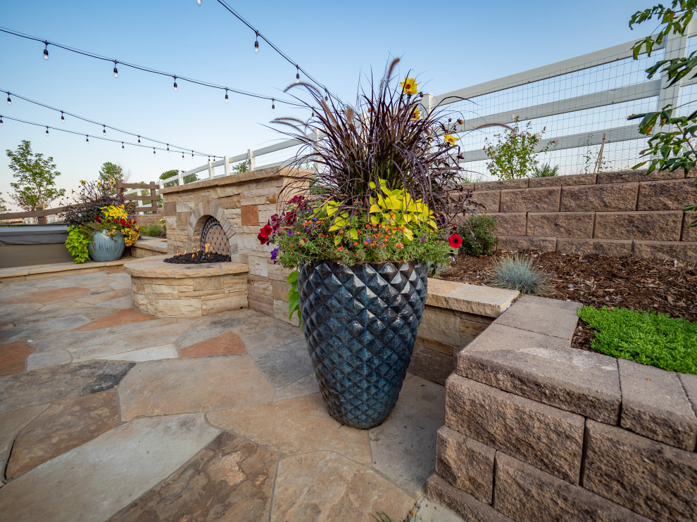 Immagine di un piccolo giardino american style esposto in pieno sole dietro casa in estate con un giardino in vaso e pavimentazioni in pietra naturale