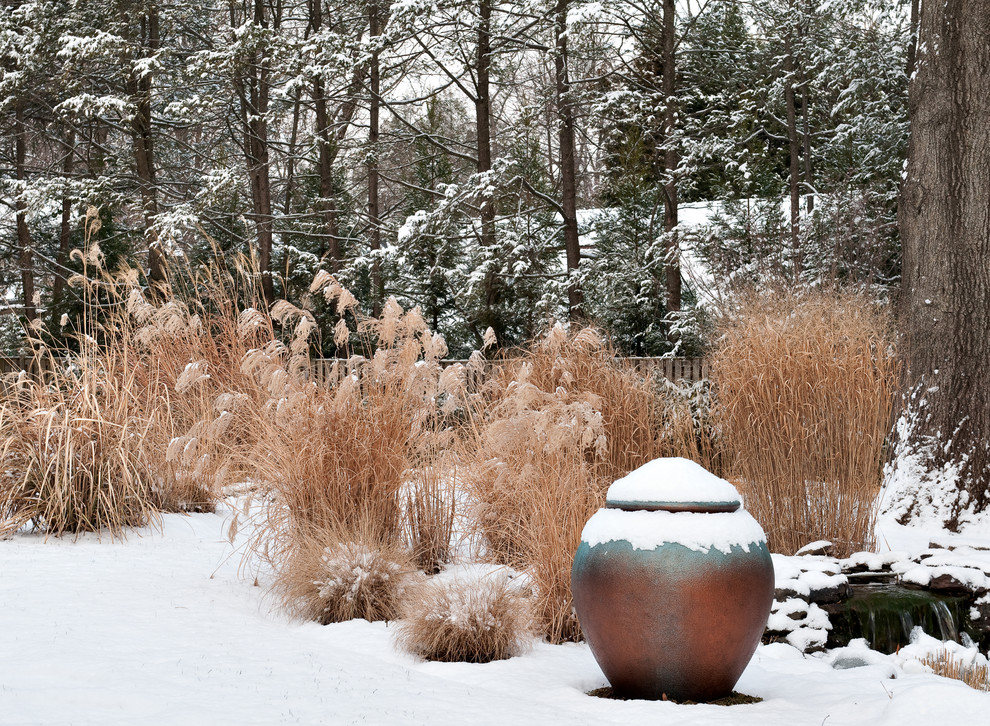 Idée de décoration pour un grand jardin arrière design l'hiver avec une exposition partiellement ombragée et des pavés en pierre naturelle.
