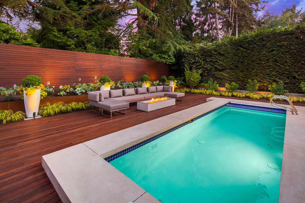 Großer, Halbschattiger Moderner Garten im Sommer, hinter dem Haus mit Wasserspiel und Dielen in Seattle