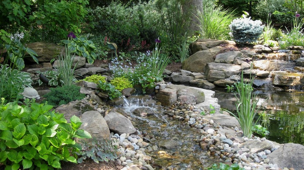 Large rustic back fully shaded garden for spring in Cleveland with a pond and gravel.