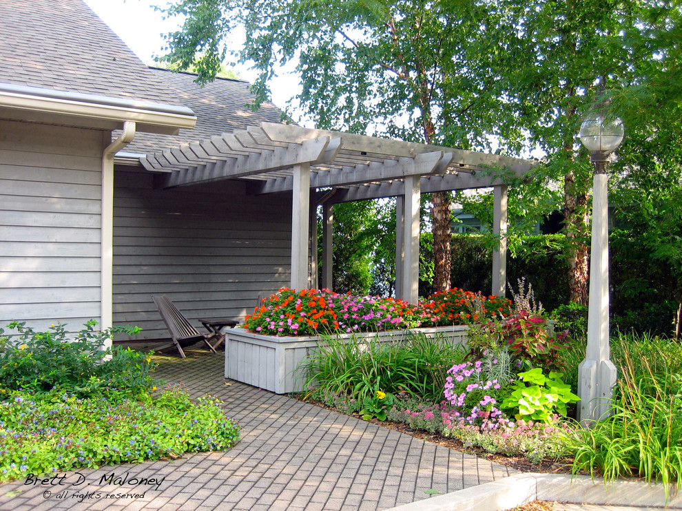 Ejemplo de jardín de secano costero de tamaño medio en verano en patio con exposición total al sol y adoquines de hormigón