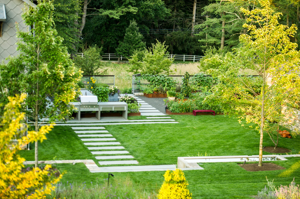Aménagement d'un jardin arrière contemporain de taille moyenne avec une exposition partiellement ombragée et des pavés en pierre naturelle.
