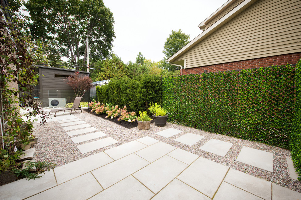 Inspiration for a medium sized contemporary partial sun garden in Montreal with concrete paving.