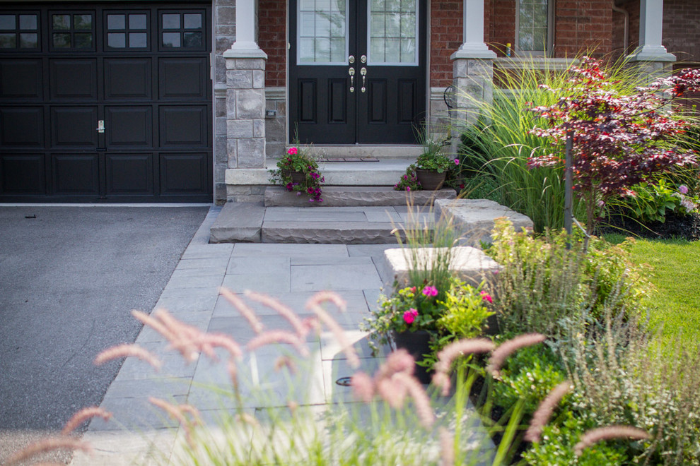 Inspiration for a medium sized contemporary front formal partial sun garden for spring in Toronto with natural stone paving and a garden path.
