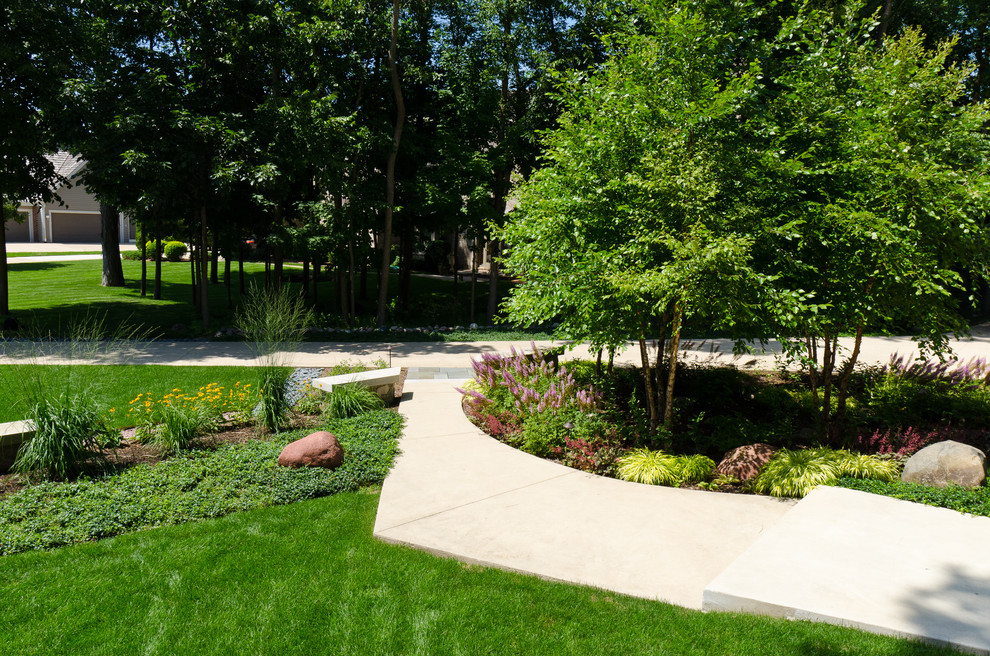 Inspiration for a large contemporary front driveway garden steps in Milwaukee with concrete paving.