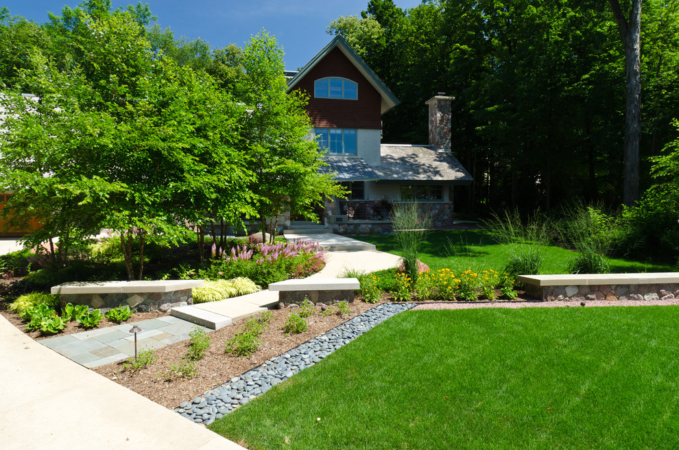 Imagen de jardín actual grande en patio delantero con adoquines de piedra natural