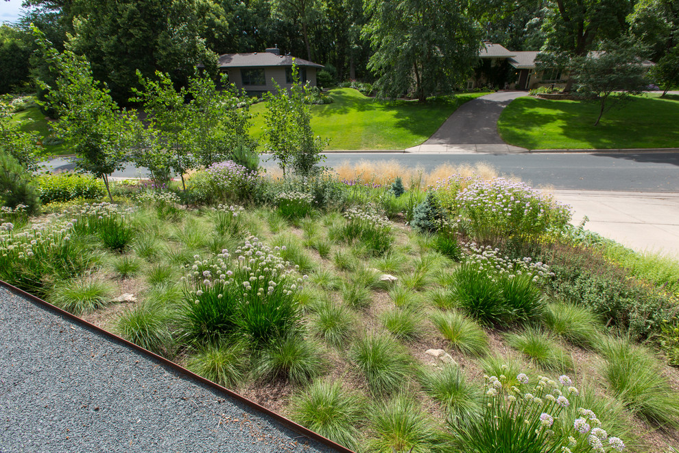 Exemple d'un jardin avant tendance avec un mur de soutènement, une exposition ensoleillée et des pavés en pierre naturelle.