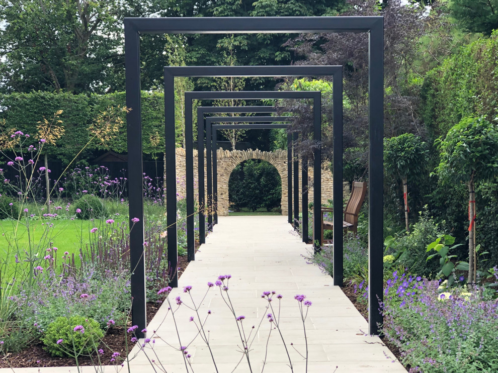 Immagine di un grande giardino formale contemporaneo esposto a mezz'ombra dietro casa con un ingresso o sentiero e pavimentazioni in pietra naturale