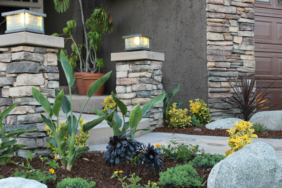 Inspiration for a medium sized contemporary front xeriscape partial sun garden for summer in Orange County with a garden path and natural stone paving.