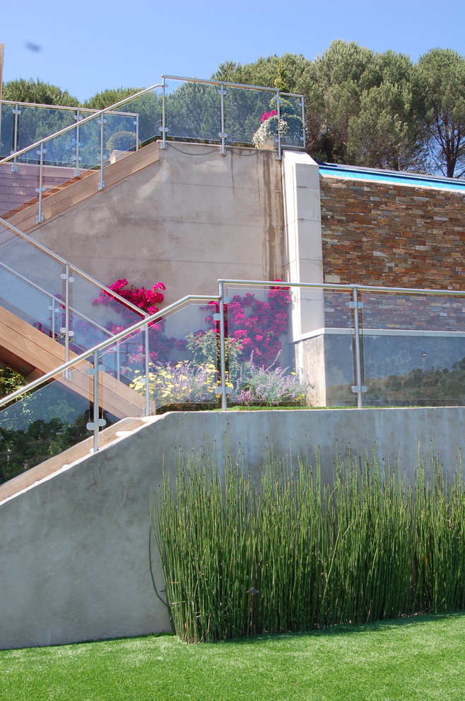 Esempio di un giardino minimalista con un pendio, una collina o una riva e scale