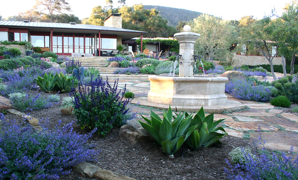 Geräumiger Moderner Garten im Sommer, hinter dem Haus mit Wasserspiel, direkter Sonneneinstrahlung und Natursteinplatten in Santa Barbara