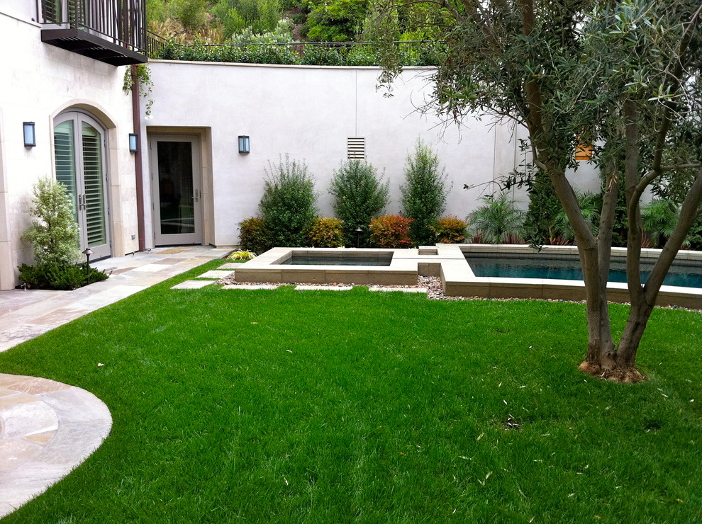 Diseño de jardín contemporáneo grande en patio trasero con fuente y adoquines de piedra natural