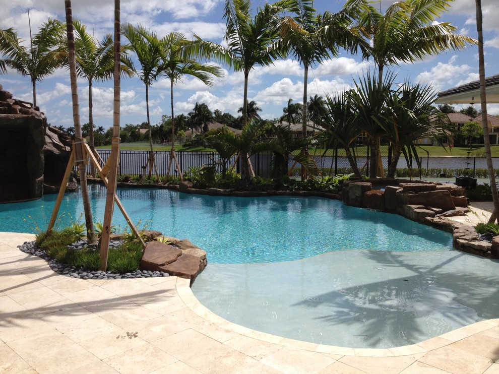 Ejemplo de piscina exótica de tamaño medio en patio trasero con entablado