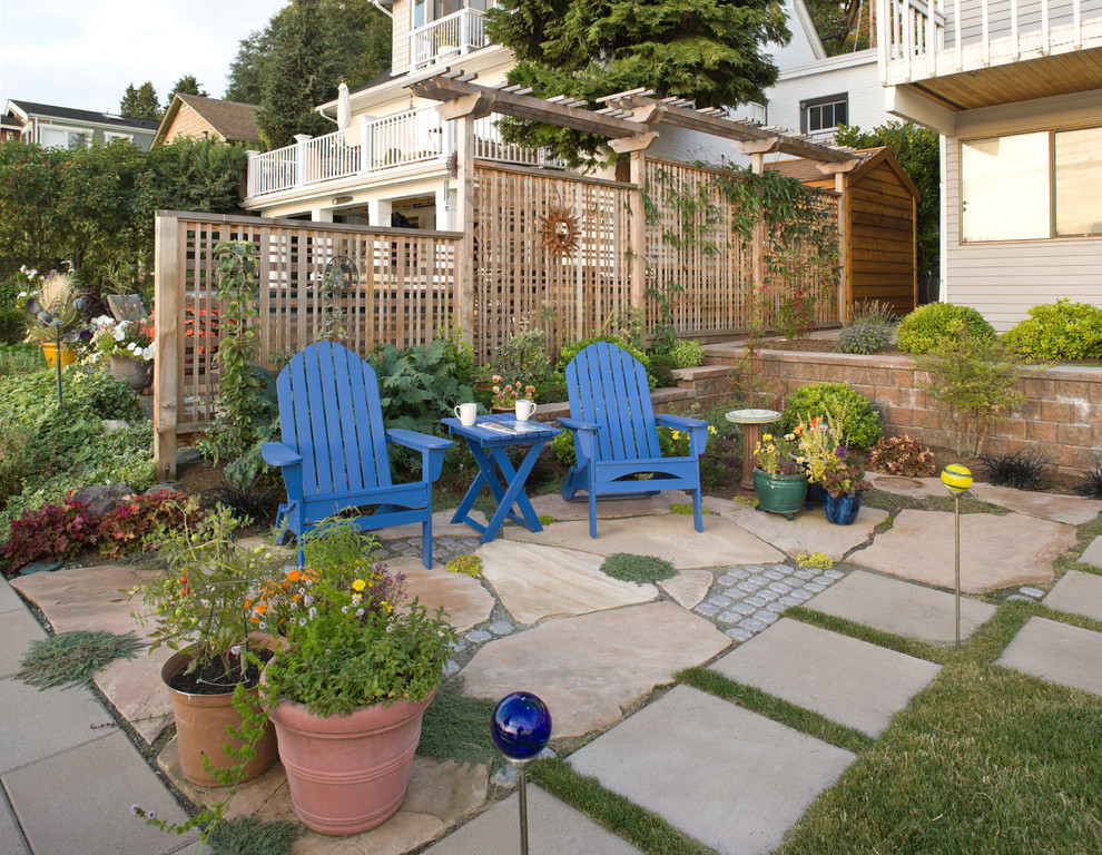 Esempio di un giardino design esposto in pieno sole di medie dimensioni e dietro casa con pavimentazioni in pietra naturale e un muro di contenimento