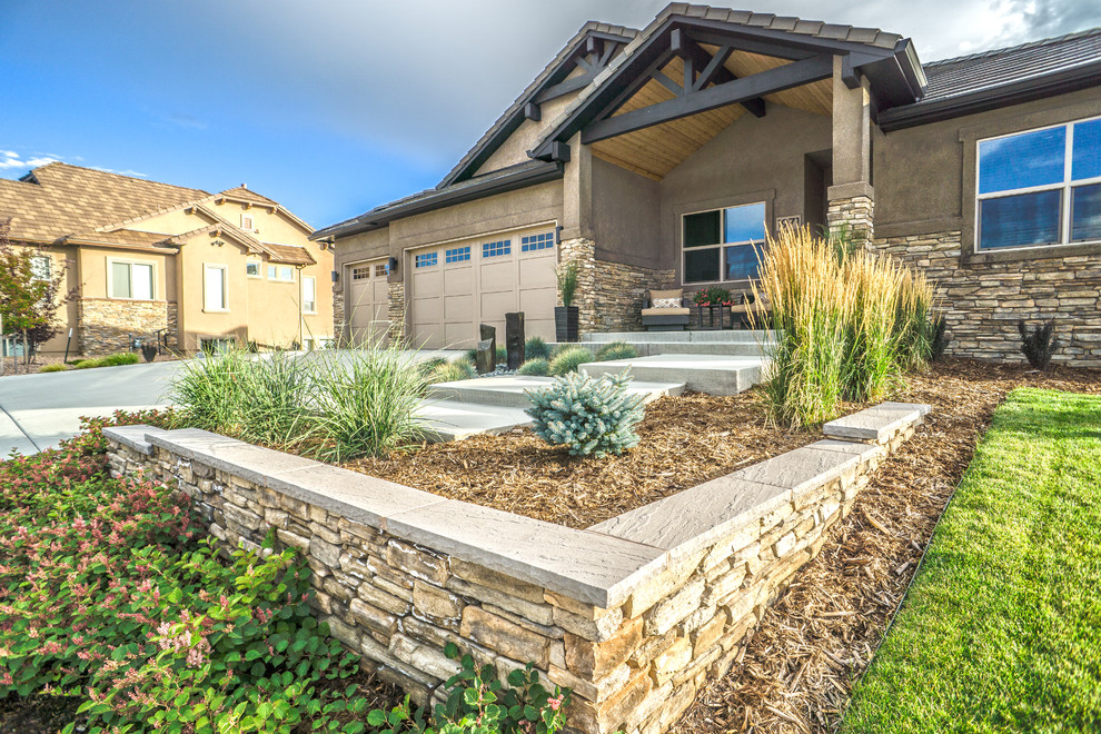 Inspiration for a large contemporary front xeriscape full sun garden for summer in Denver with a retaining wall and concrete paving.