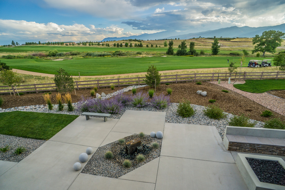Inspiration for a large contemporary shade and drought-tolerant backyard concrete paver landscaping in Denver with a fire pit for winter.