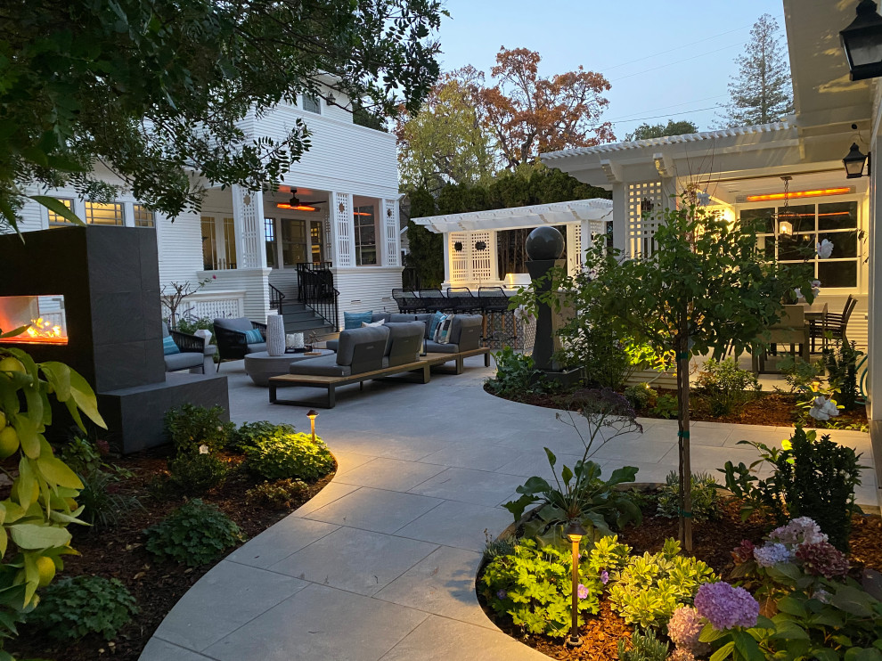 Стильный дизайн: маленький солнечный участок и сад на заднем дворе в стиле неоклассика (современная классика) с уличным камином, хорошей освещенностью и покрытием из каменной брусчатки для на участке и в саду - последний тренд